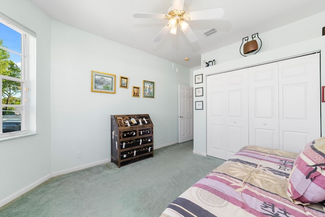 carpeted bedroom with ceiling fan and a closet