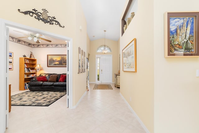 entryway featuring light tile patterned floors, ceiling fan, and vaulted ceiling