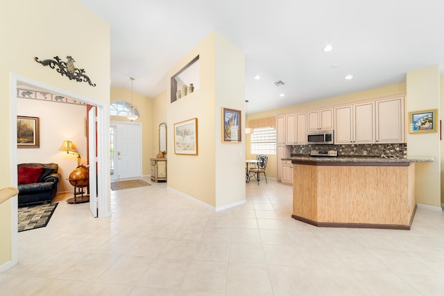 kitchen featuring light brown cabinetry, light tile patterned floors, decorative backsplash, and hanging light fixtures