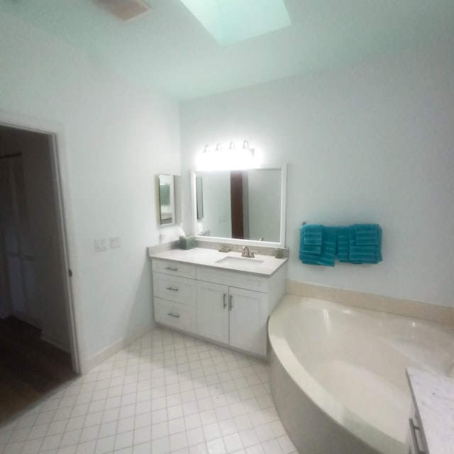 bathroom with vanity, a skylight, and a washtub