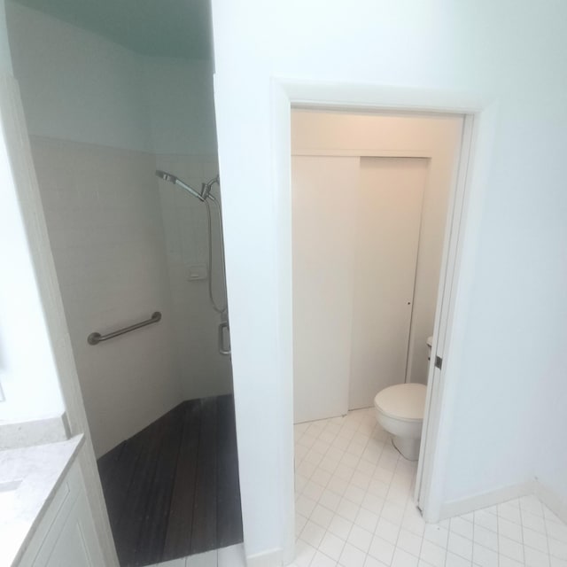 bathroom with toilet, tile patterned flooring, walk in shower, and vanity