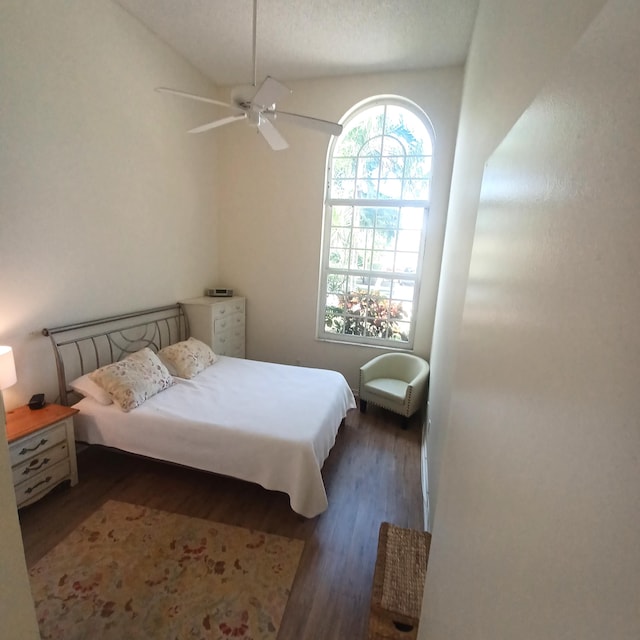 bedroom with ceiling fan, vaulted ceiling, and dark wood-type flooring