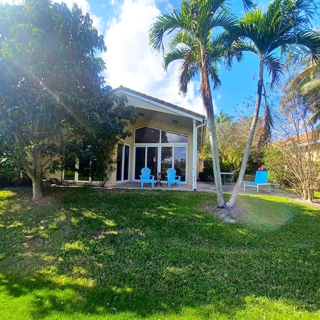 rear view of house featuring a patio and a yard