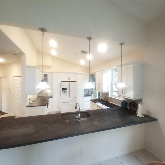 kitchen featuring decorative light fixtures, white cabinets, kitchen peninsula, and white fridge with ice dispenser