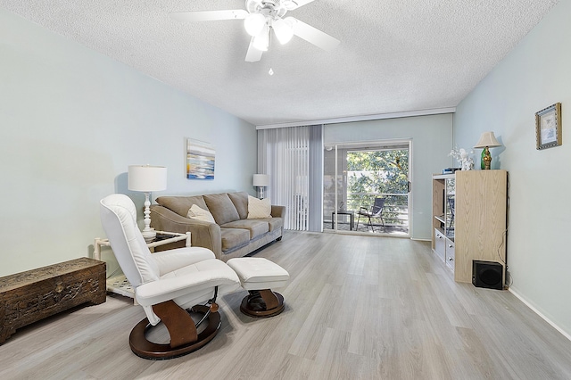 living room featuring a textured ceiling, light hardwood / wood-style flooring, and ceiling fan