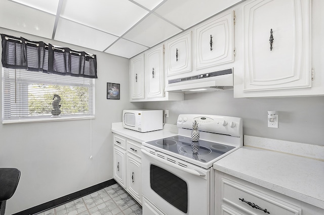 kitchen with white cabinets, white appliances, and a paneled ceiling