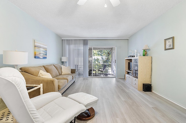 living room with ceiling fan, light hardwood / wood-style floors, and a textured ceiling