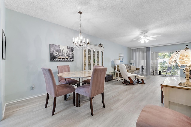 dining area with ceiling fan with notable chandelier, light wood-type flooring, and a textured ceiling