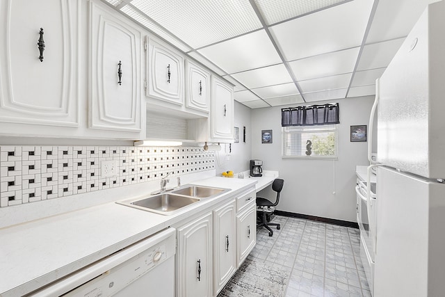 kitchen featuring a drop ceiling, white appliances, white cabinets, sink, and decorative backsplash