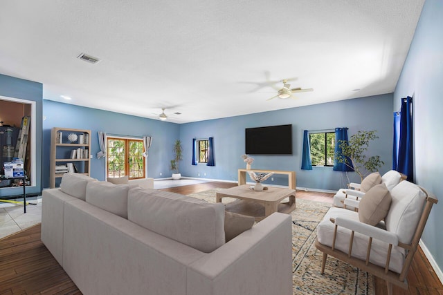 living room with ceiling fan, hardwood / wood-style floors, and a textured ceiling