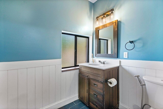 bathroom with tile patterned flooring, vanity, and toilet