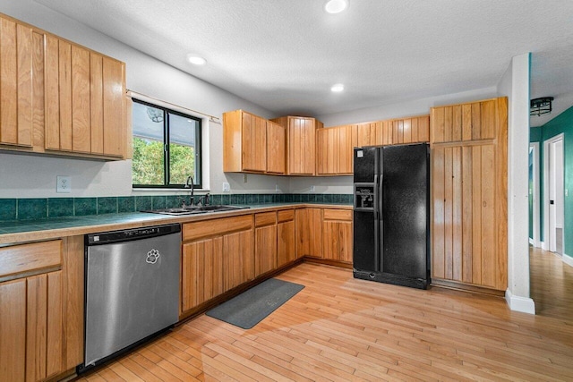 kitchen featuring dishwasher, sink, black refrigerator with ice dispenser, a textured ceiling, and light wood-type flooring