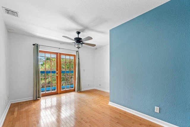 empty room with ceiling fan and light hardwood / wood-style flooring