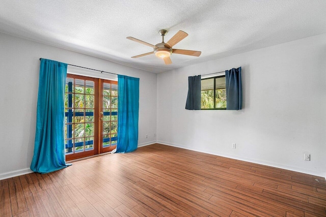 unfurnished room with a healthy amount of sunlight, a textured ceiling, and wood-type flooring