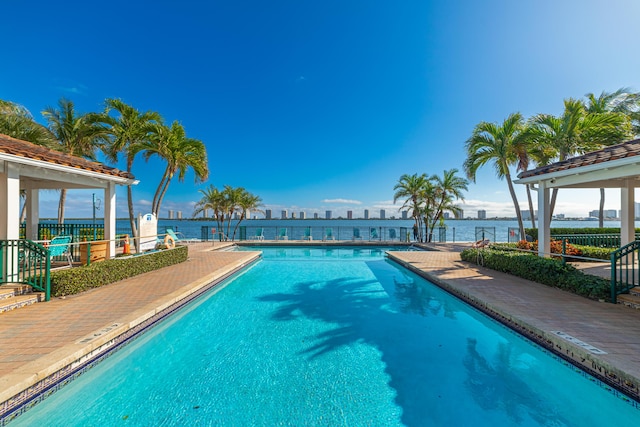 view of pool with a patio area and a water view