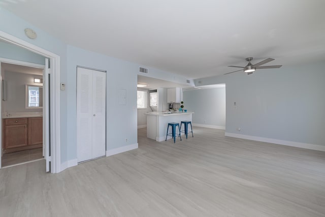 unfurnished living room with light wood-type flooring and ceiling fan