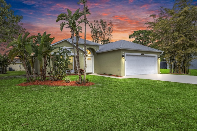 view of front of house featuring a garage and a yard