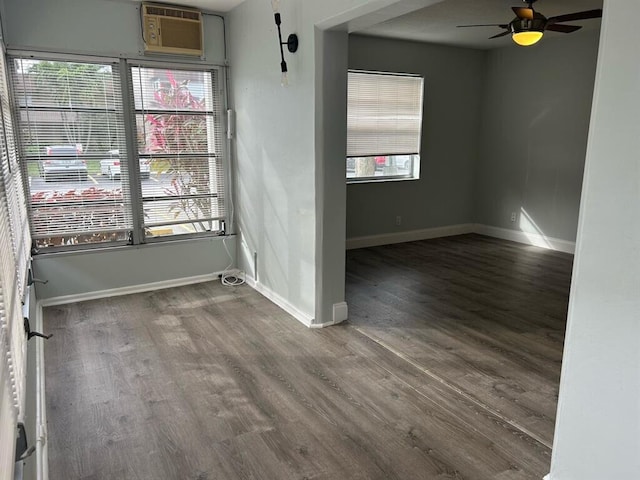 empty room with hardwood / wood-style floors, ceiling fan, and an AC wall unit