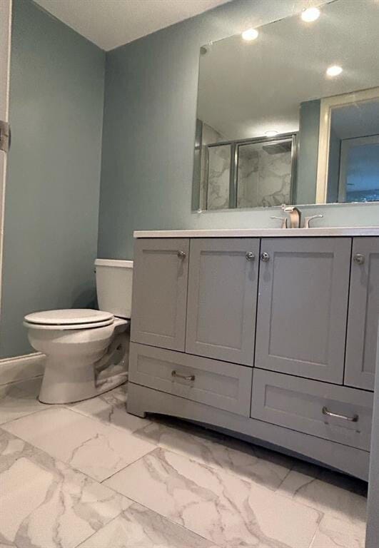 bathroom featuring vanity, toilet, and an enclosed shower