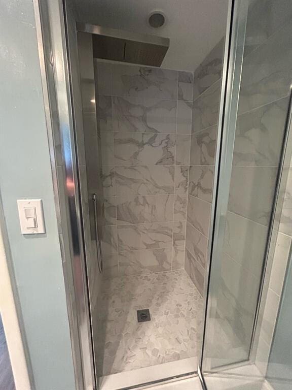 bathroom with a shower with door