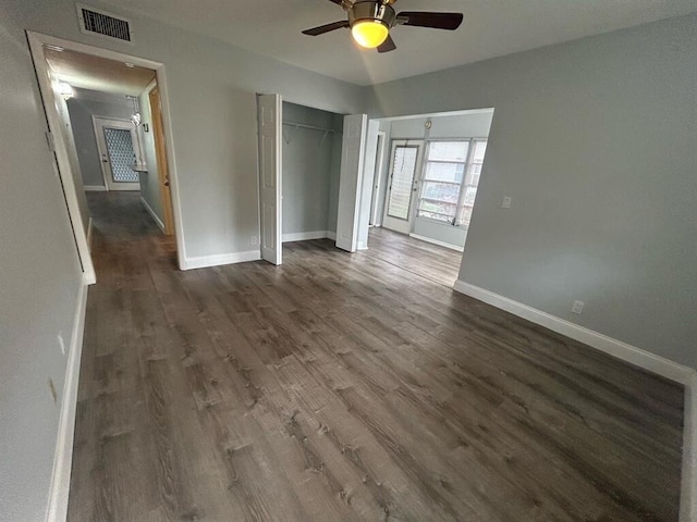 unfurnished bedroom featuring ceiling fan, dark hardwood / wood-style flooring, and a closet