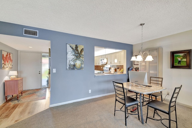 dining area with a textured ceiling and an inviting chandelier