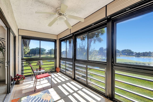 sunroom featuring a water view and ceiling fan