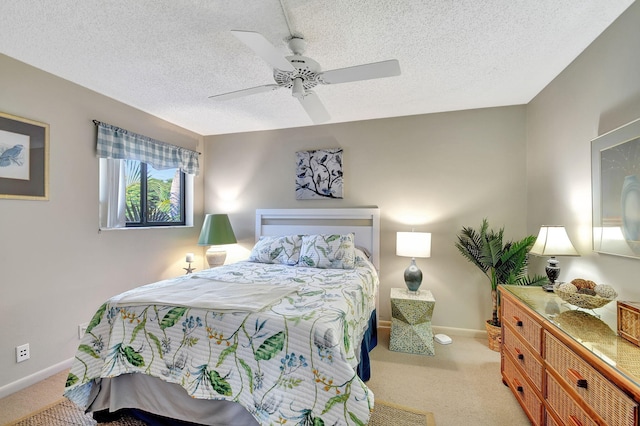 bedroom featuring ceiling fan, light carpet, and a textured ceiling