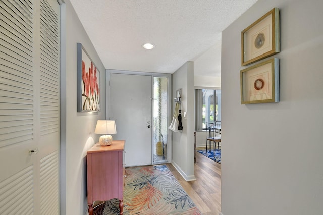 entrance foyer featuring a textured ceiling and light wood-type flooring