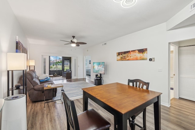 dining area featuring light wood-type flooring and ceiling fan