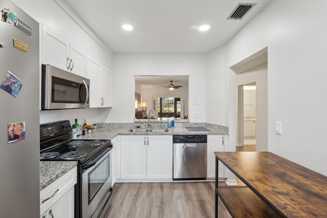 kitchen featuring stainless steel appliances, white cabinets, sink, and ceiling fan