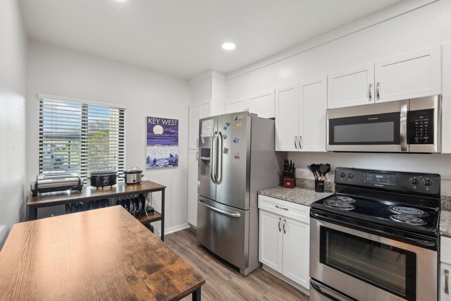 kitchen featuring light hardwood / wood-style flooring, stainless steel appliances, white cabinetry, and light stone countertops