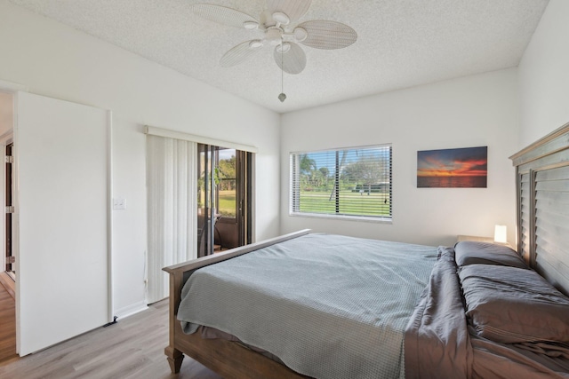 bedroom featuring ceiling fan, light hardwood / wood-style flooring, and a textured ceiling