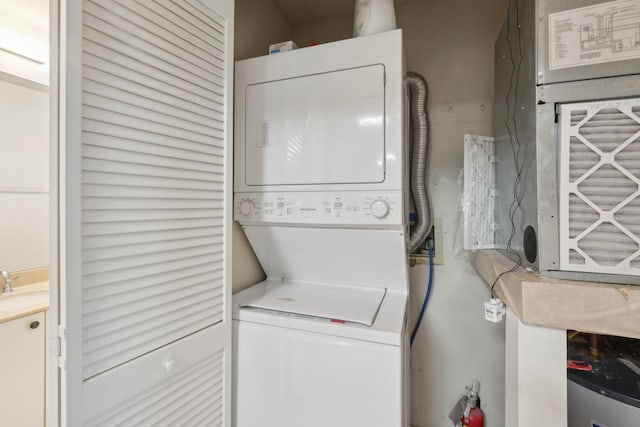 washroom featuring stacked washer and dryer and sink