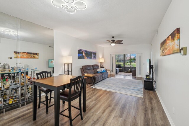 dining space with ceiling fan and wood-type flooring