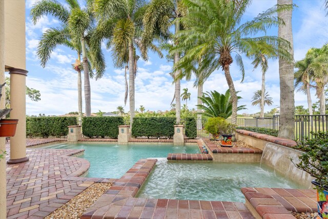 view of swimming pool with pool water feature and an in ground hot tub