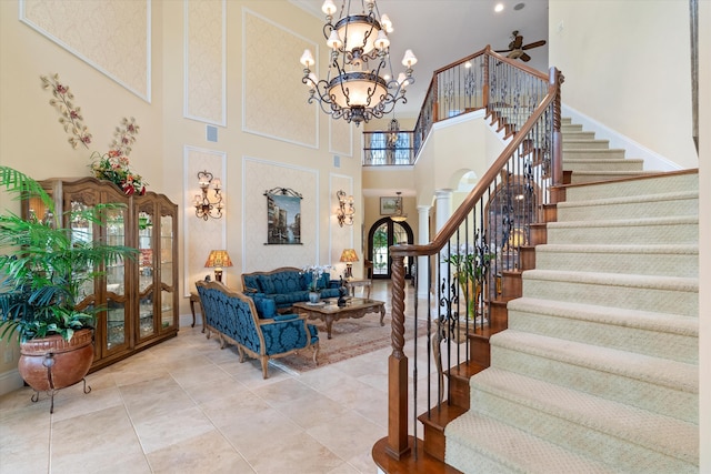 tiled entrance foyer with a notable chandelier and a high ceiling