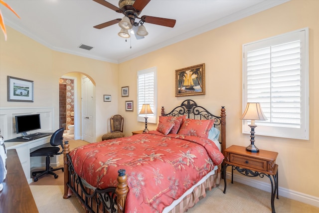 bedroom with ornamental molding, light colored carpet, ceiling fan, and ensuite bath