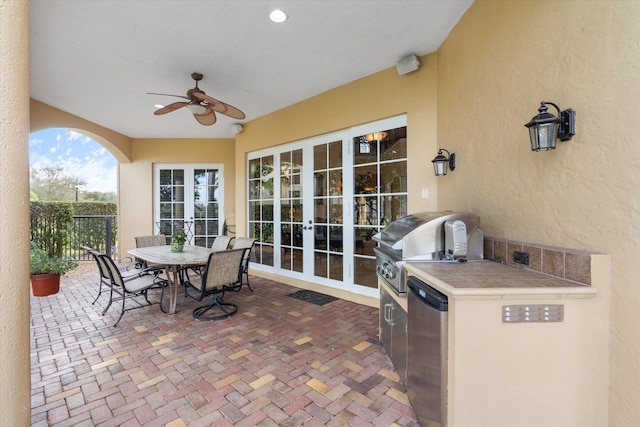 view of patio / terrace with a grill, french doors, ceiling fan, and exterior kitchen