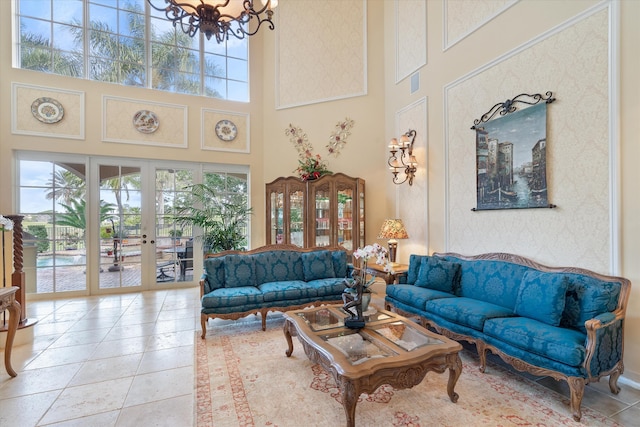 interior space featuring an inviting chandelier, a towering ceiling, and french doors