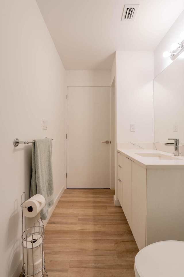 bathroom featuring vanity, hardwood / wood-style floors, and toilet