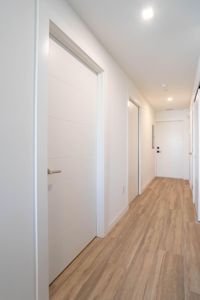 hallway with light hardwood / wood-style flooring