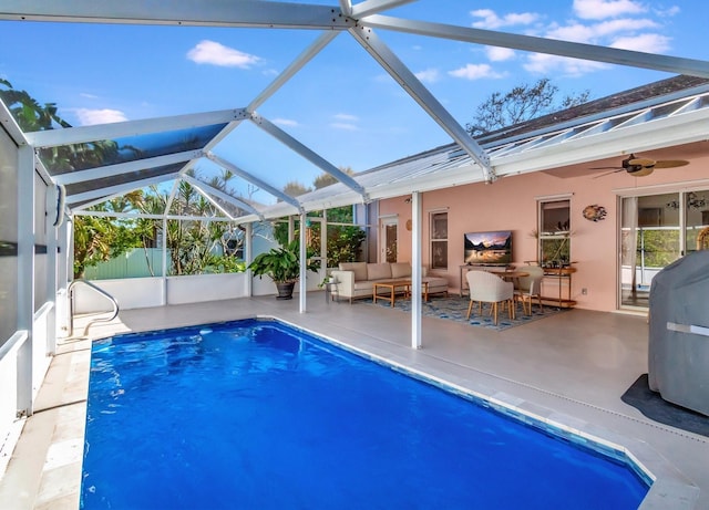 view of swimming pool featuring an outdoor living space, ceiling fan, glass enclosure, and a patio