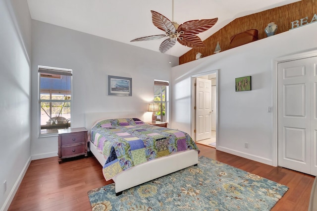 bedroom with ceiling fan, dark hardwood / wood-style floors, and lofted ceiling