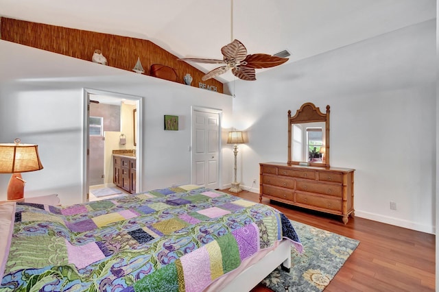 bedroom featuring ceiling fan, hardwood / wood-style floors, ensuite bathroom, and lofted ceiling