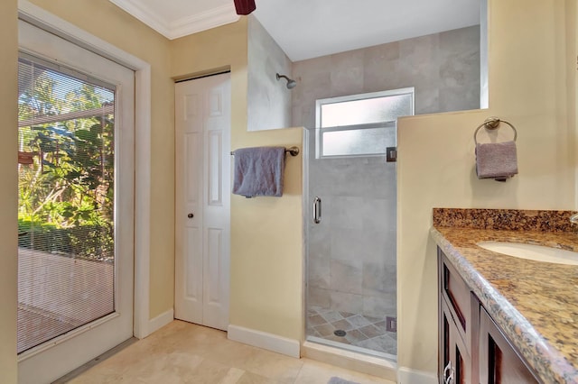 bathroom with plenty of natural light, ornamental molding, walk in shower, and vanity