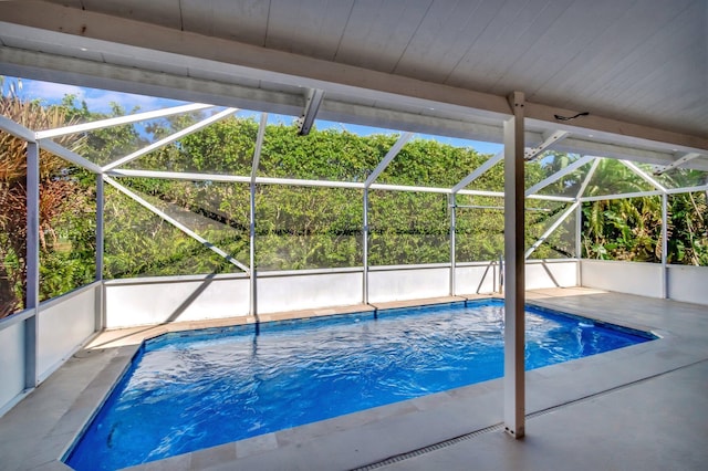 view of swimming pool with a patio area and a lanai