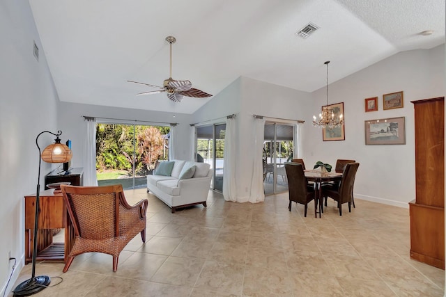 interior space with a textured ceiling, ceiling fan with notable chandelier, light tile patterned flooring, and vaulted ceiling