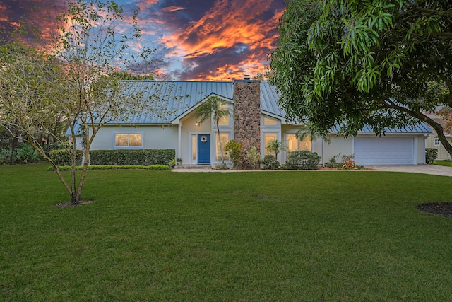 view of front of property featuring a garage and a yard