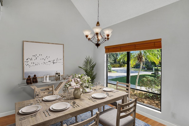 dining area with a wealth of natural light, light hardwood / wood-style flooring, lofted ceiling, and a notable chandelier